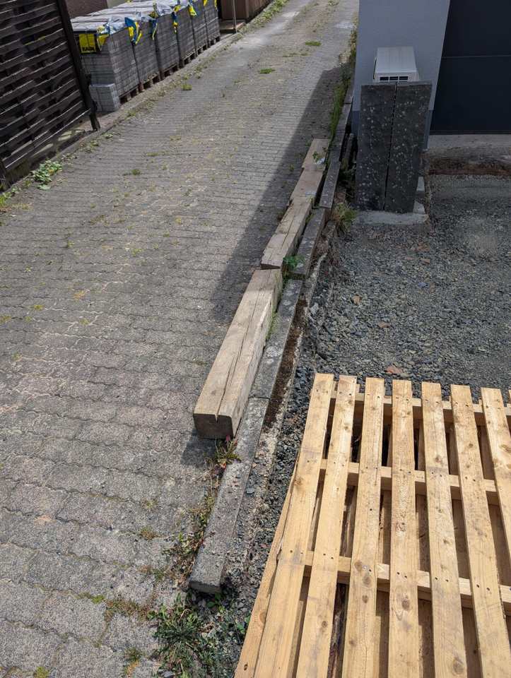 Beschädigte Bordsteine entlang einer Einfahrt vor Beginn der Sanierung