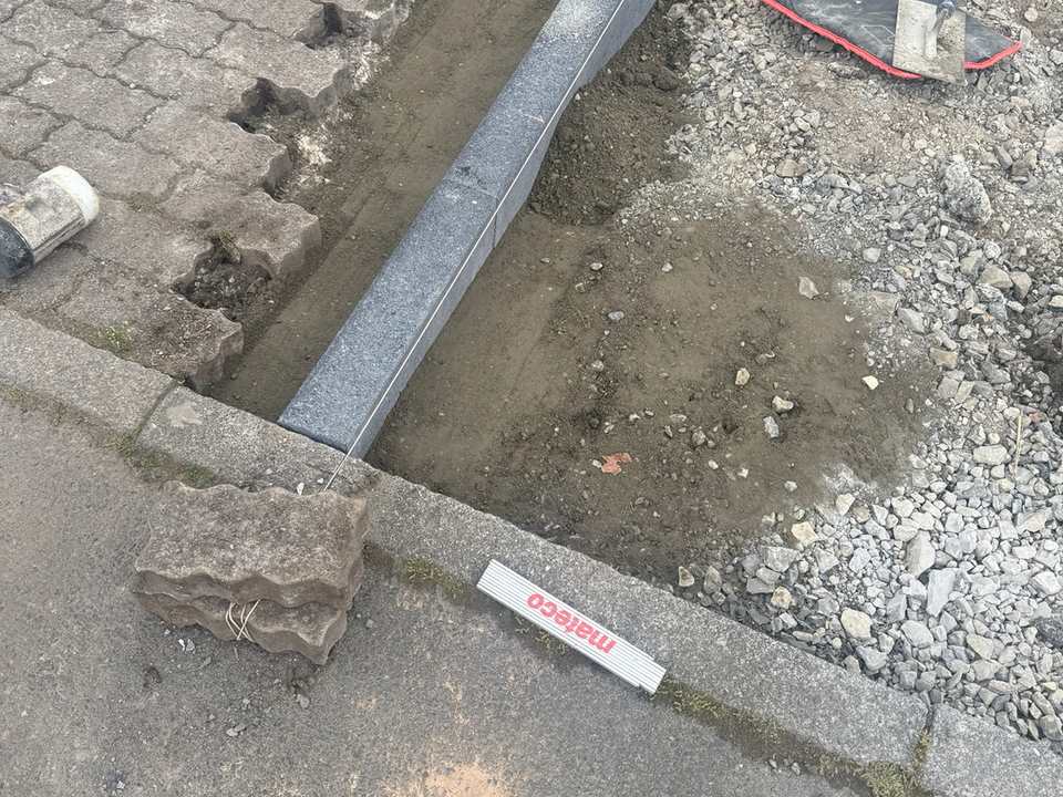 Versetzen neuer Bordsteine in Betonbett