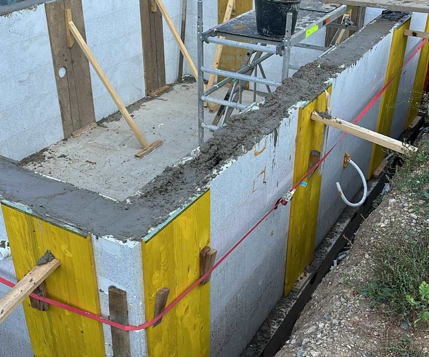 Poolwände während der Betonarbeiten mit Schalung und abgestütztem Rohbau