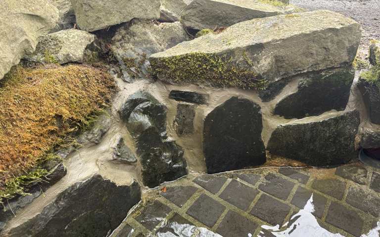 Gesamtansicht der instandgesetzten Kneippanlage an der Löwenburg in Kassel mit Natursteinbachlauf und Pflasterfläche