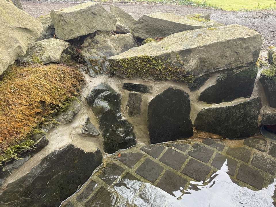 Gesamtansicht der instandgesetzten Kneippanlage an der Löwenburg in Kassel mit Natursteinbachlauf und Pflasterfläche