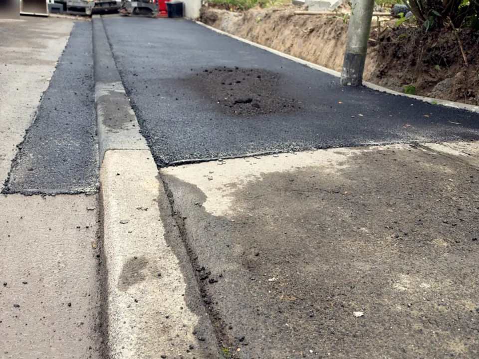 Sauberer Anschluss der neuen Asphaltdecke an den Bestand bei der Bordsteinabsenkung