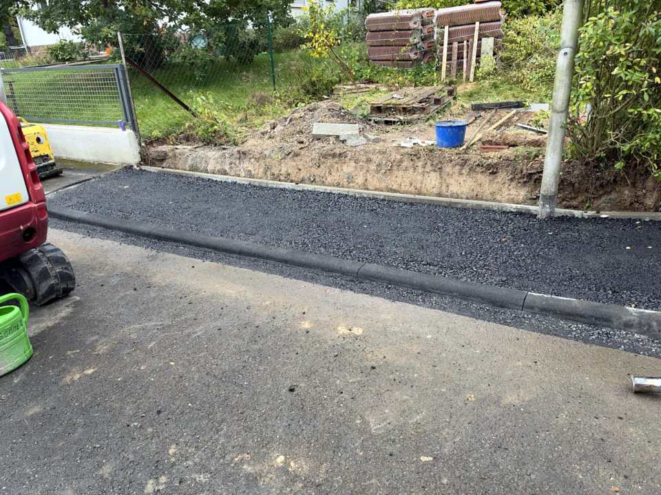 Asphalteinbau hinter dem abgesenkten Bordstein an einer Grundstückseinfahrt in Kassel
