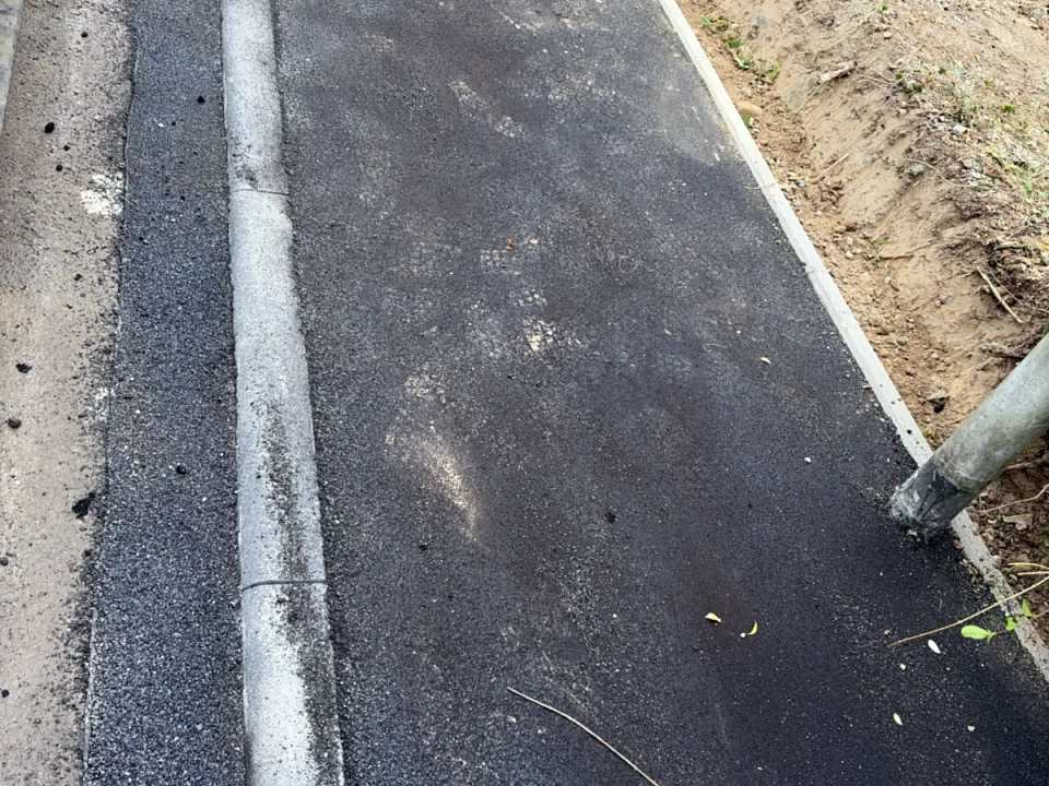 Fertige Bordsteinabsenkung mit neuer Asphaltdecke und Tiefbord – Draufsicht
