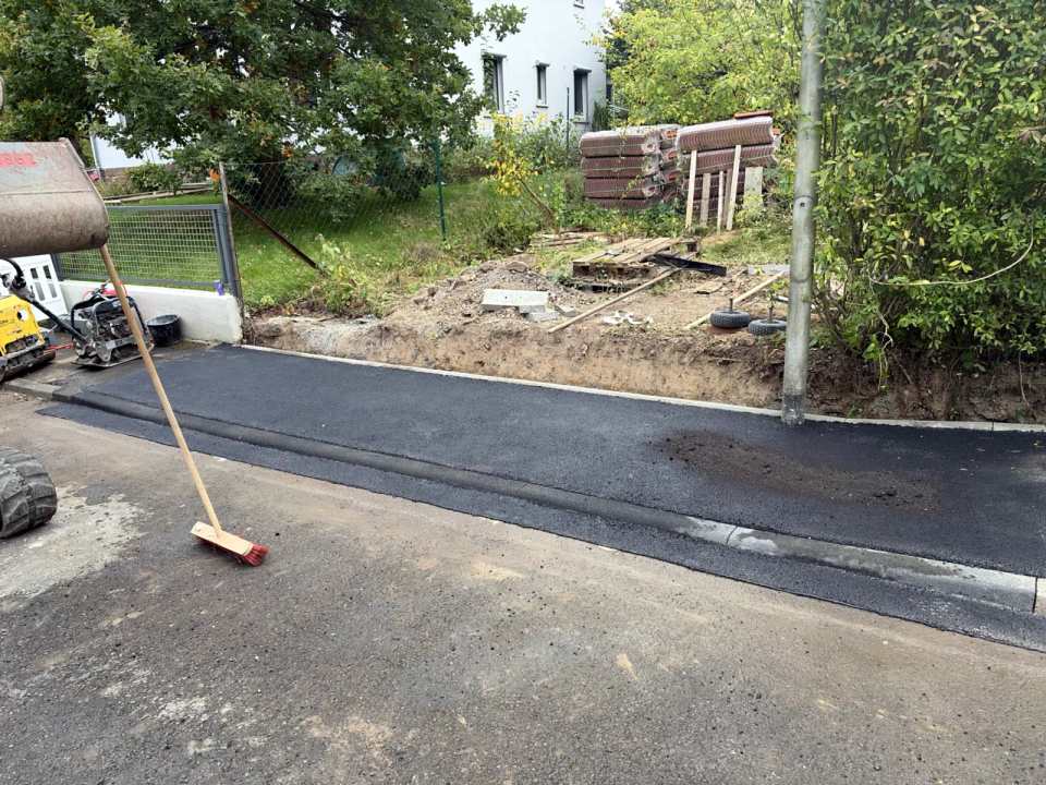 Nachher: fertig abgesenkter Bordstein mit neuer Asphaltfläche an der Grundstückseinfahrt in Kassel