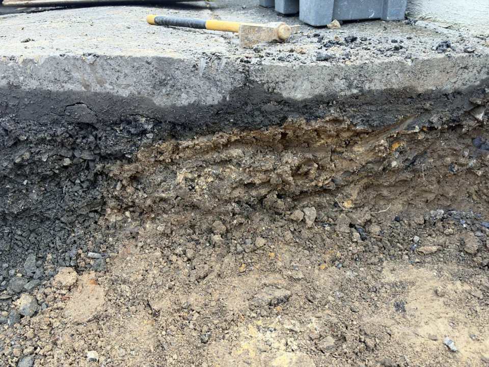 Bodenprofil unter altem Gehwegbelag: Asphalt, Tragschicht und Boden vor dem Neuaufbau