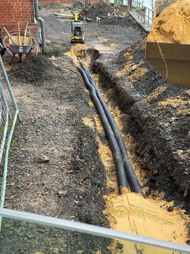 Verlegte Leerrohre im vorbereiteten Sandbett auf dem Gelände eines Pumpenwerks in Kassel