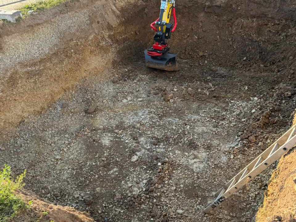 Ausgehobene und vorbereitete Baugrube für den Poolbau mit Bagger