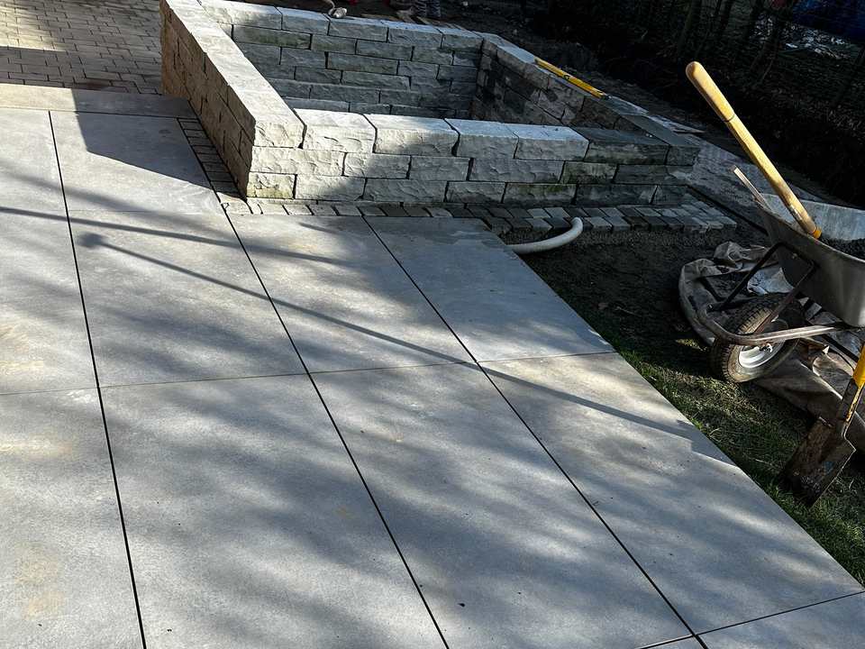 Gepflasterter Gartenweg mit angrenzender dichter Bepflanzung