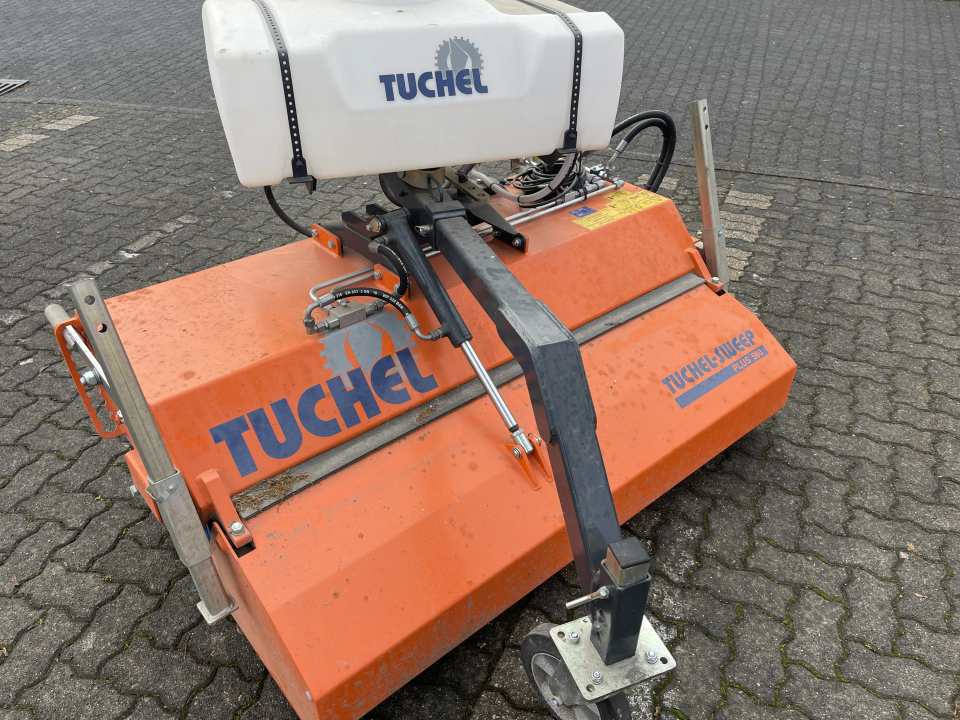 Orangefarbene hydraulische Kehrmaschine mit Wassertank auf einer gepflasterten Hoffläche