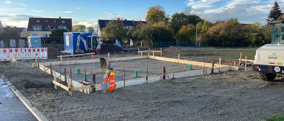 Große rechteckige Schalung mit Schotterunterbau und mehreren Rohrdurchführungen auf einer Baustelle