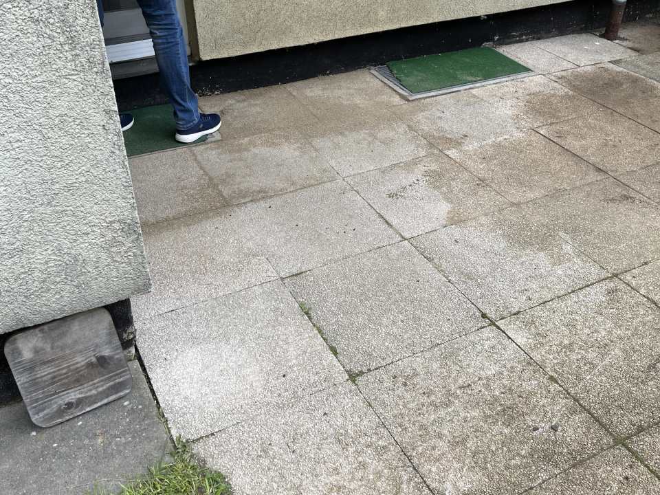 Ältere Betonplattenfläche direkt am Hauseingang mit sichtbaren Fugen und Gebrauchsspuren